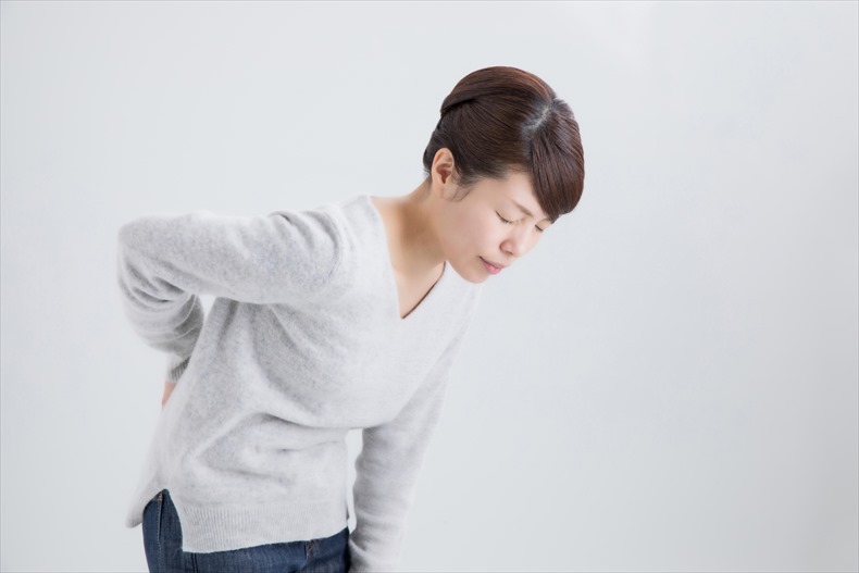反り腰から起こる腰痛に苦しむ女性