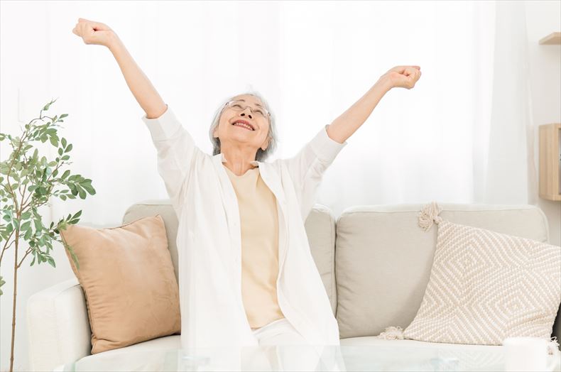 背伸びをして体を動かす高齢の女性